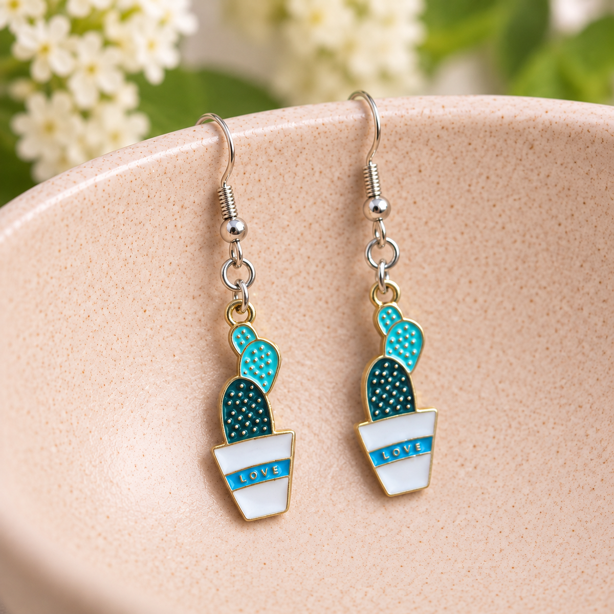Cacti Love Earrings with silver-tone hooks on a blush speckled bowl