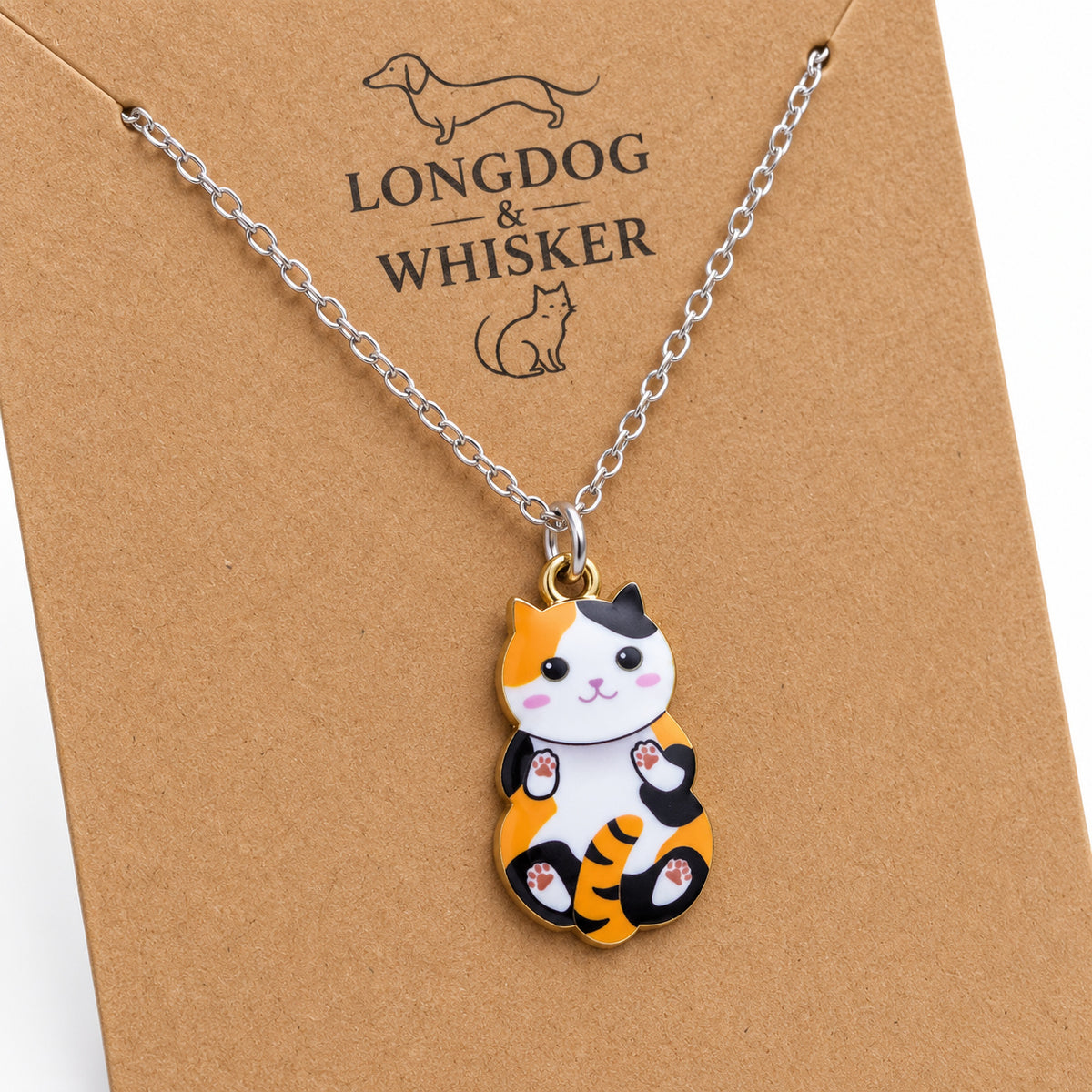 Close-up of the calico cat pendant with orange and black patches, pink paw pads and mixed-tone fittings