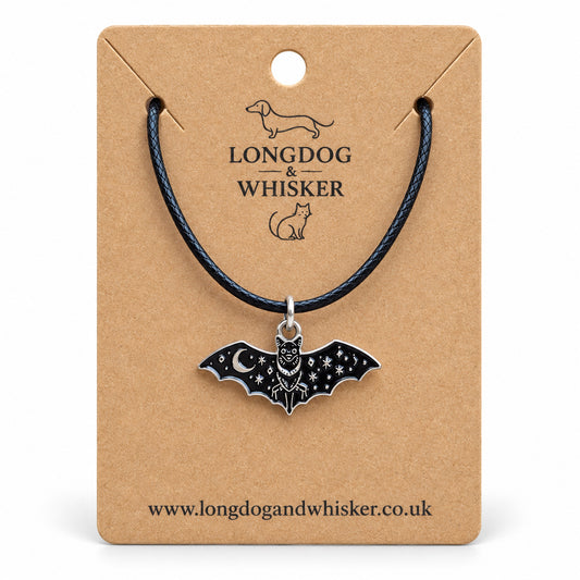 Celestial moon bat necklace on a black cord, displayed on a Longdog & Whisker kraft card