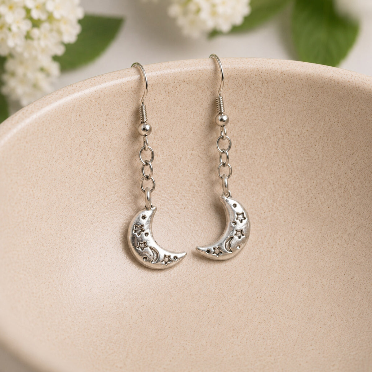Celestial Moon Earrings hanging inside a ceramic bowl