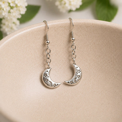 Celestial Moon Earrings hanging inside a ceramic bowl