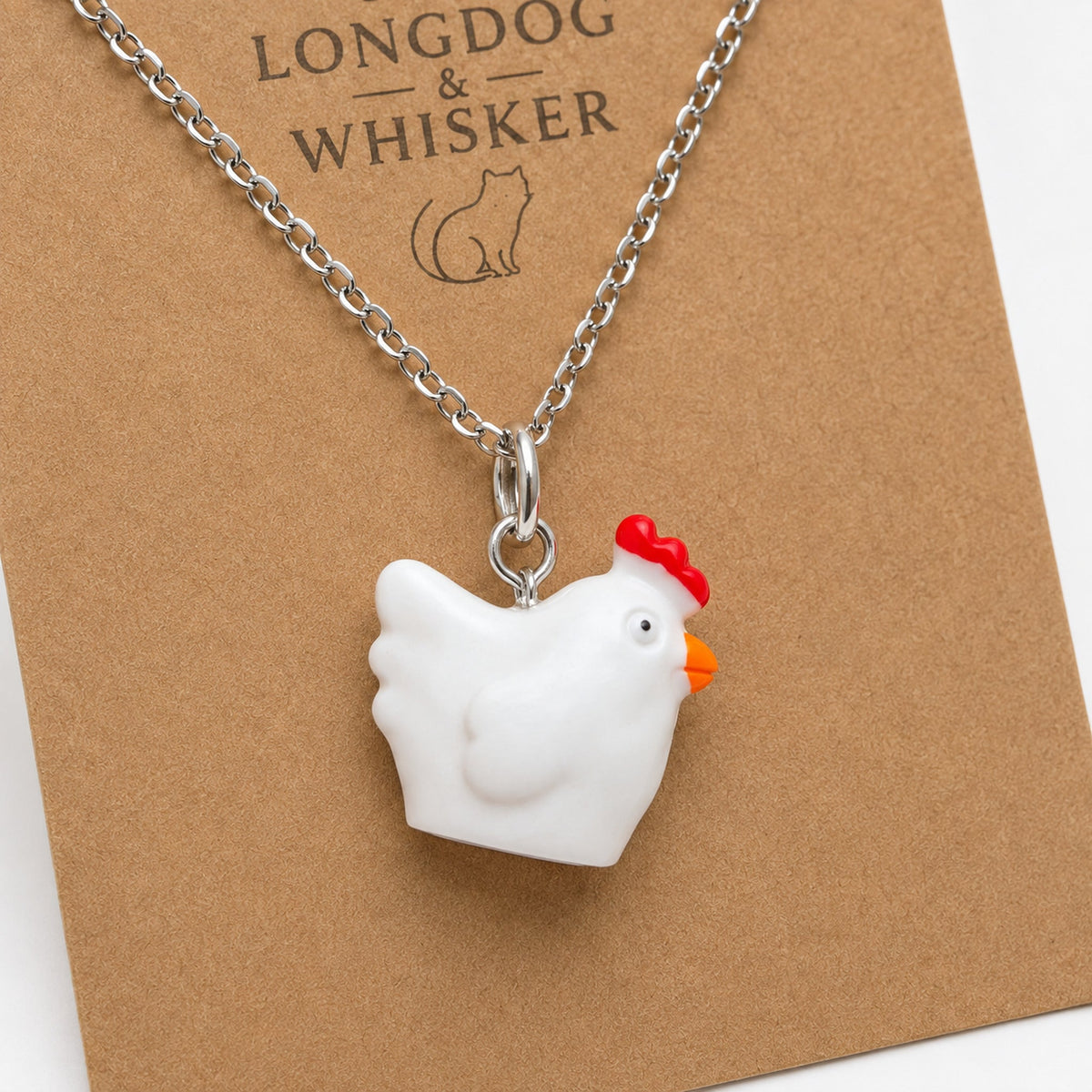 Close-up of the white chicken charm on a silver-tone necklace chain