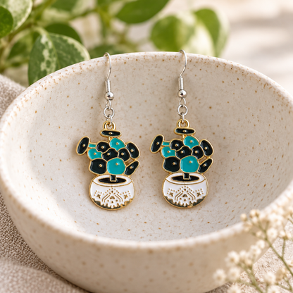 Coin Leaf Plant Pot Earrings hanging from a ceramic bowl with silver hooks