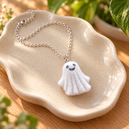 Dancing Ghost Necklace in a speckled ceramic bowl
