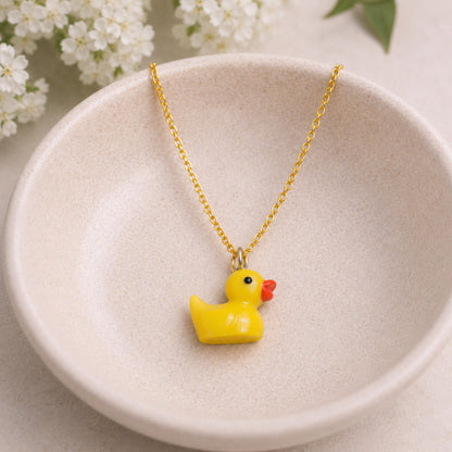 Rubber Duck Necklace with gold chain in bowl lifestyle scene
