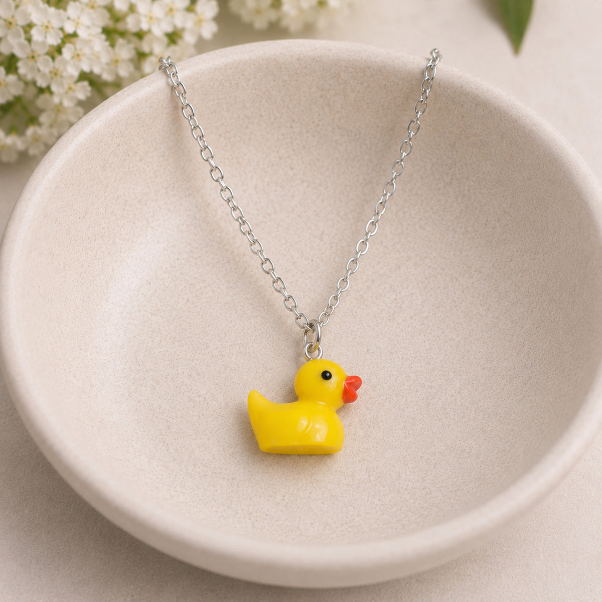 Rubber Duck Necklace with silver chain in bowl lifestyle scene