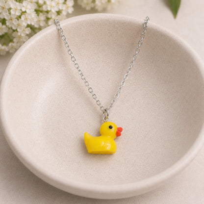 Rubber Duck Necklace with silver chain in bowl lifestyle scene