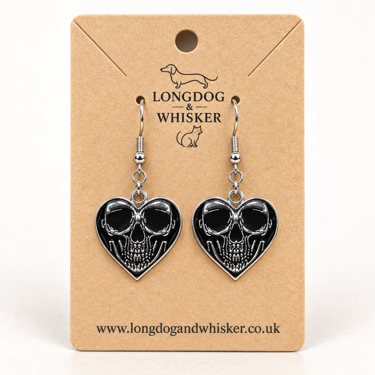 Front-facing skull heart drop earrings on a Longdog & Whisker kraft product card