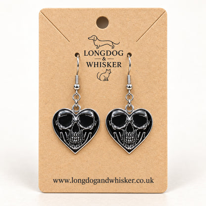 Front-facing skull heart drop earrings on a Longdog & Whisker kraft product card