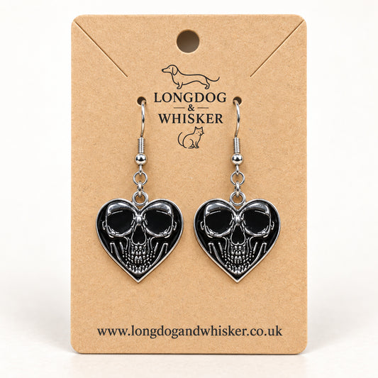 Front-facing skull heart drop earrings on a Longdog & Whisker kraft product card