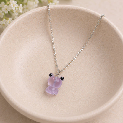 Frosted Frog in Lilac Necklace displayed on a ceramic bowl