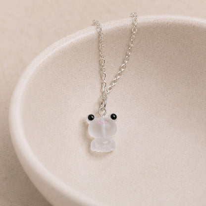 Frosted Frog in White Necklace displayed on a ceramic bowl