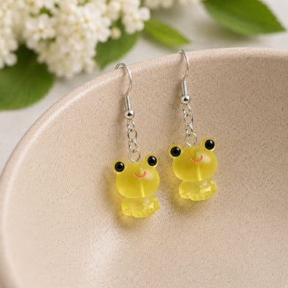Frosted Frog in Yellow Earrings hooked over a ceramic bowl