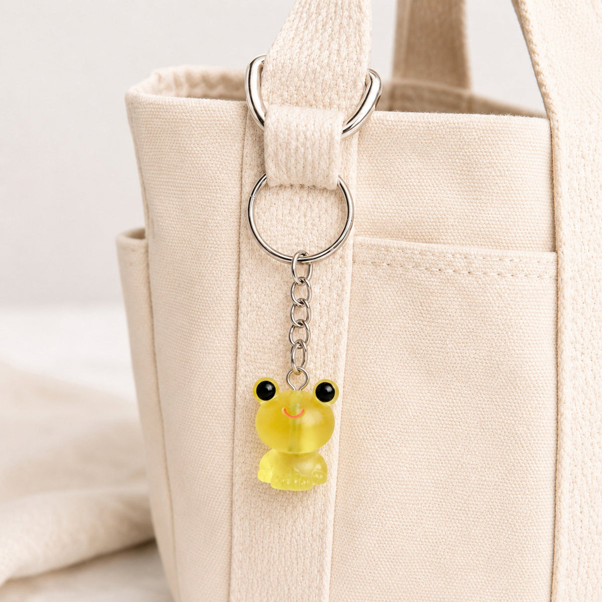 Frosted Frog in Yellow Keyring & Bag Charm attached to a cream canvas bag