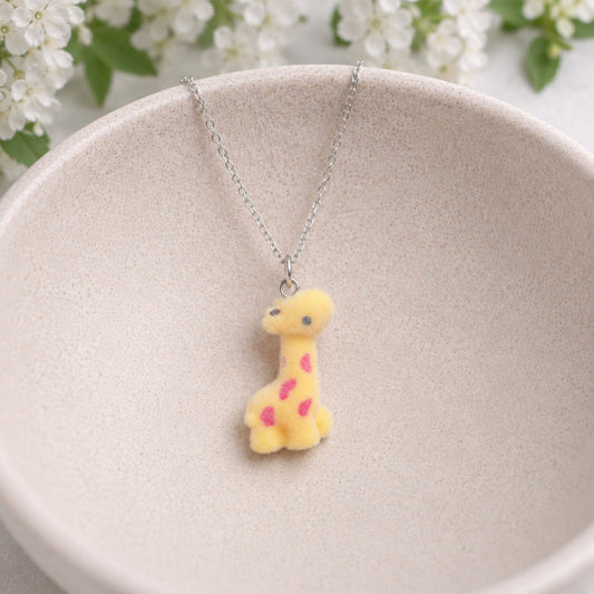 Fuzzy Giraffe Necklace displayed in a ceramic bowl
