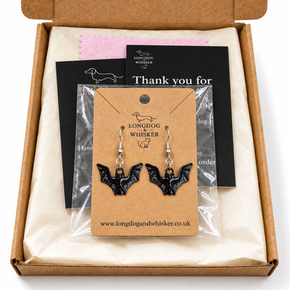 Gloss black bat drop earrings on their kraft card inside Longdog & Whisker packaging