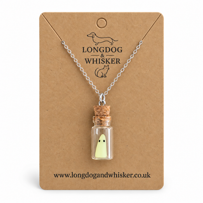 Pale-green ghost in a corked glass bottle necklace on a Longdog & Whisker kraft card