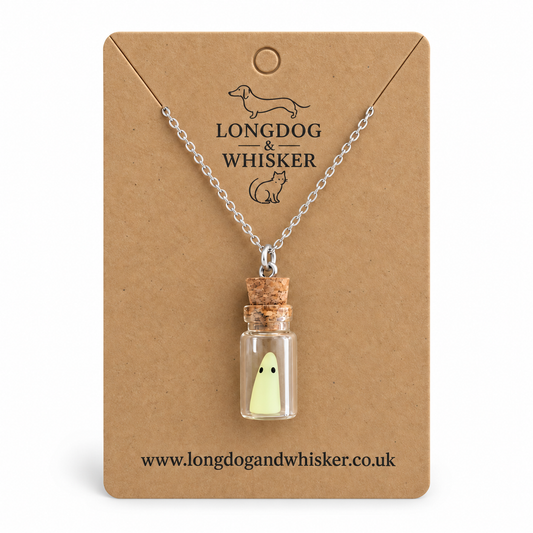 Pale-green ghost in a corked glass bottle necklace on a Longdog & Whisker kraft card