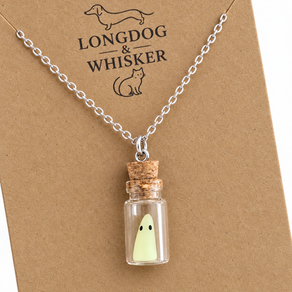 Close-up of the pale-green ghost, glass bottle, cork and silver-tone necklace connectors