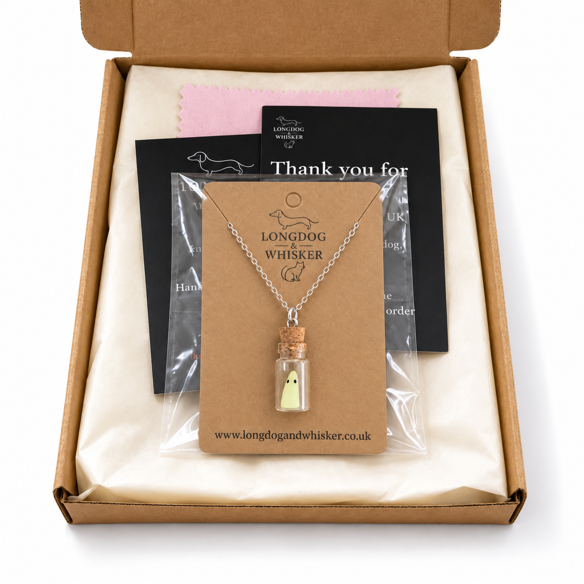 Ghost in a bottle necklace on its kraft card in Longdog & Whisker gift-ready postal packaging