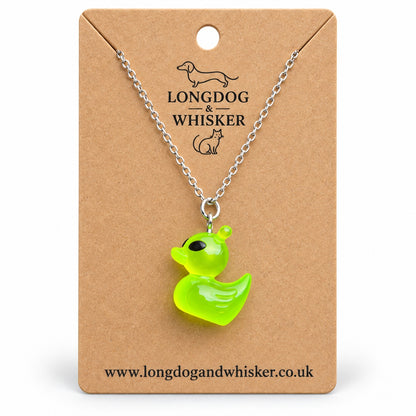 Green alien duck necklace on its Longdog & Whisker kraft product card