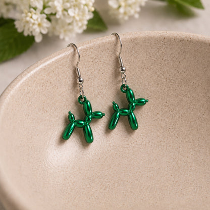 Green Balloon Dog Earrings hanging from a ceramic bowl