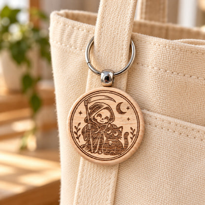 Grim Reaper and black cat wooden keyring attached to a cream canvas tote bag