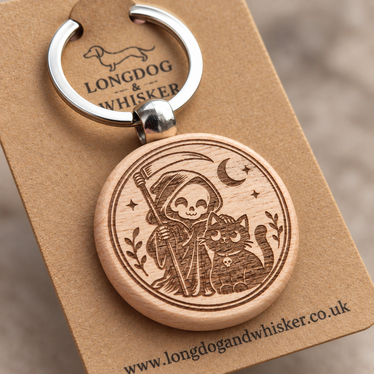 Close-up of Grim Reaper and black cat engraving on round wooden keyring