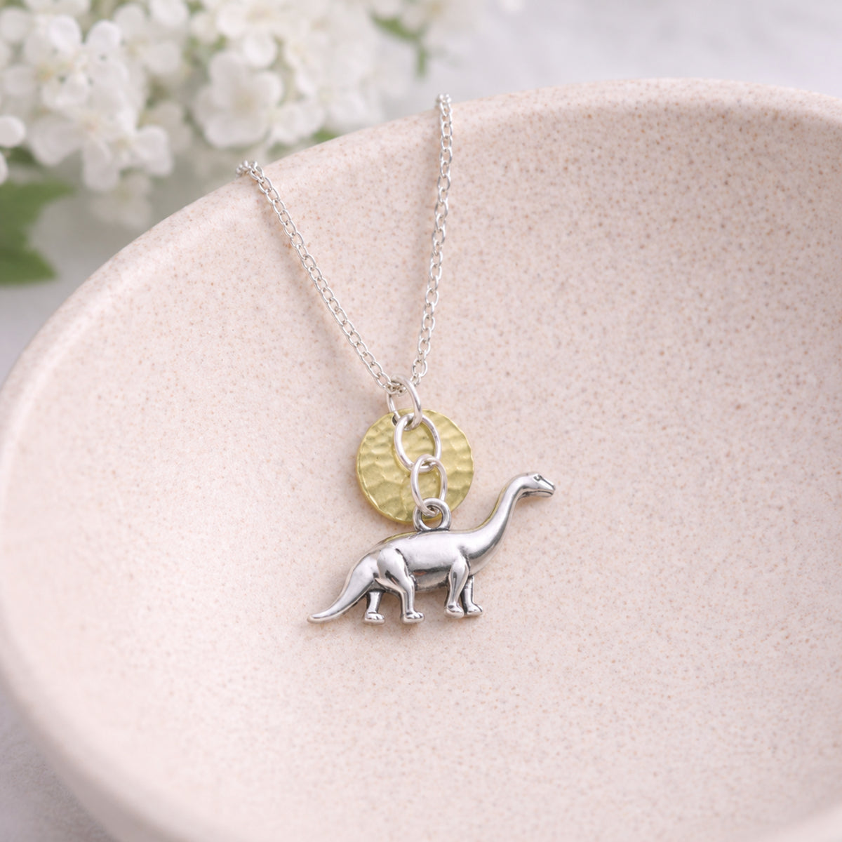 Silver Brontosaurus Dinosaur Necklace displayed in a lifestyle product photo