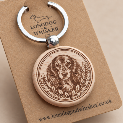 Close-up of long-haired Dachshund portrait, leafy border, wood edge and silver connector