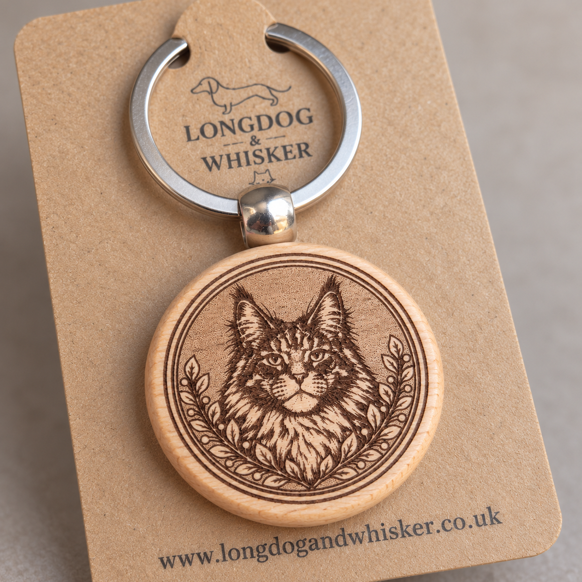 Close-up of Maine Coon portrait engraving, leafy frame and rounded wooden keyring edge