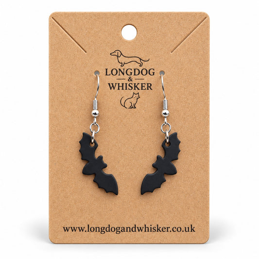 Matte black bat silhouette drop earrings on a Longdog & Whisker kraft card