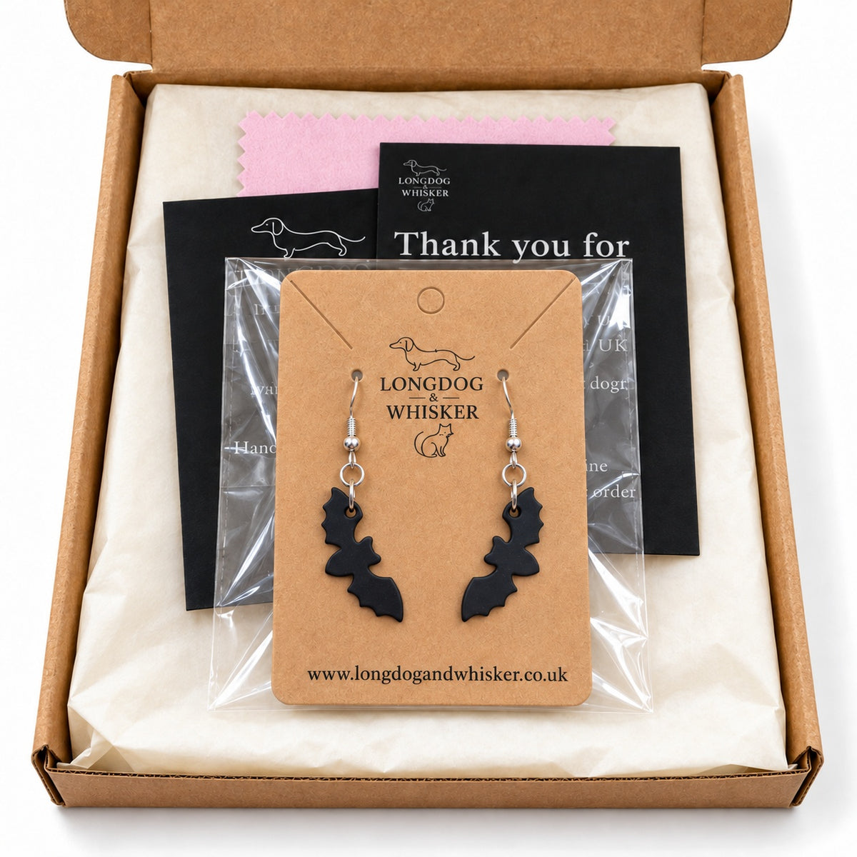 Matte black bat drop earrings on their kraft card in Longdog & Whisker packaging