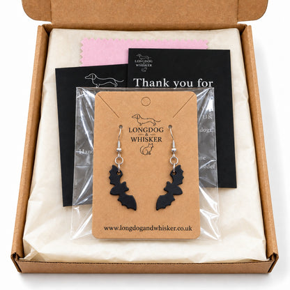 Matte black bat drop earrings on their kraft card in Longdog & Whisker packaging