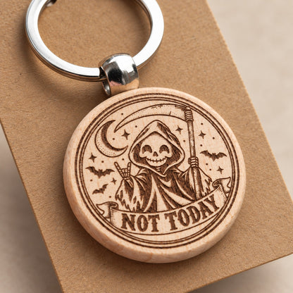 Close detail of the Not Today grim reaper engraving on a wooden keyring