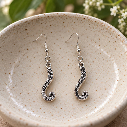 Octopus tentacle drop earrings in a speckled ceramic bowl