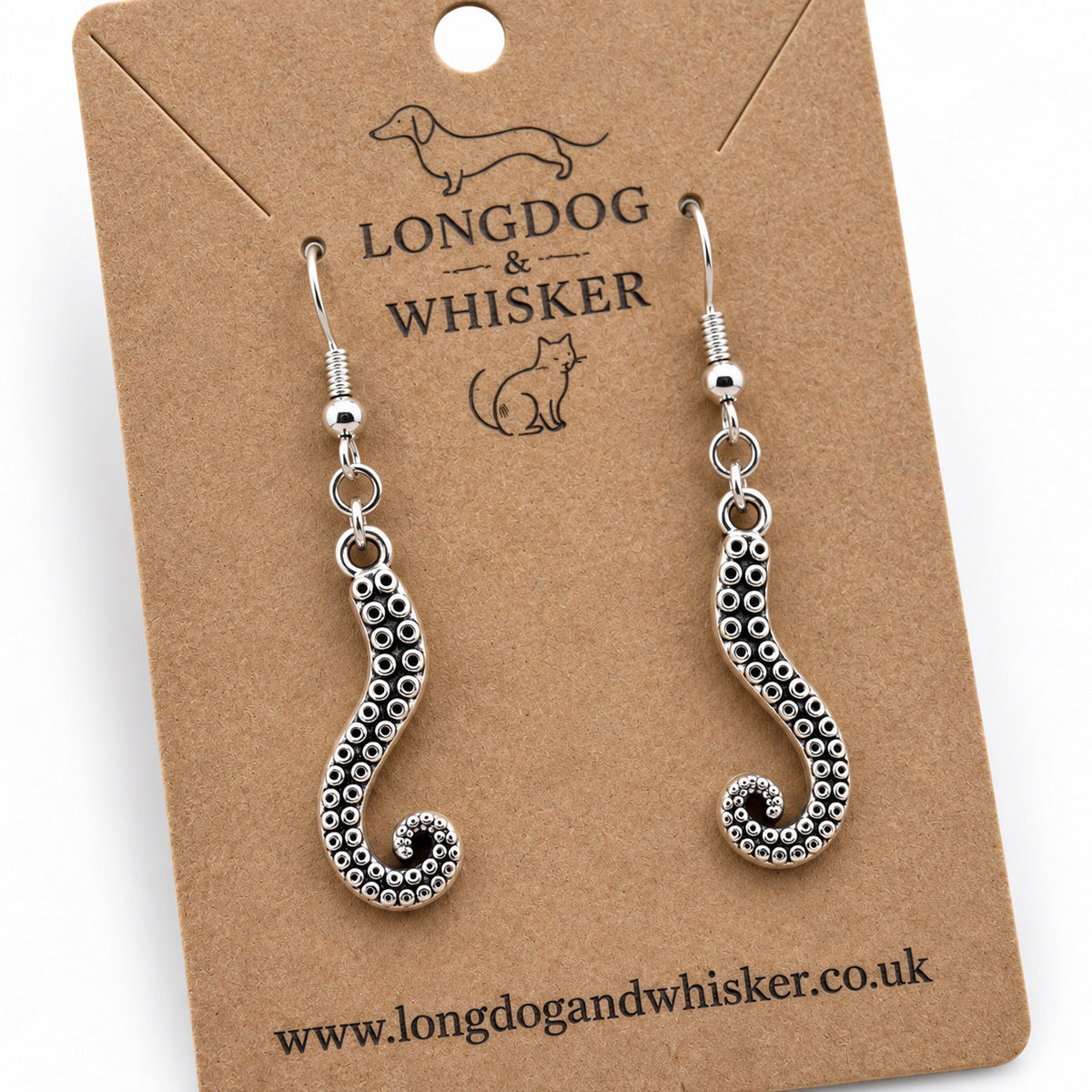Close-up of silver-coloured octopus tentacle drop earrings on kraft card