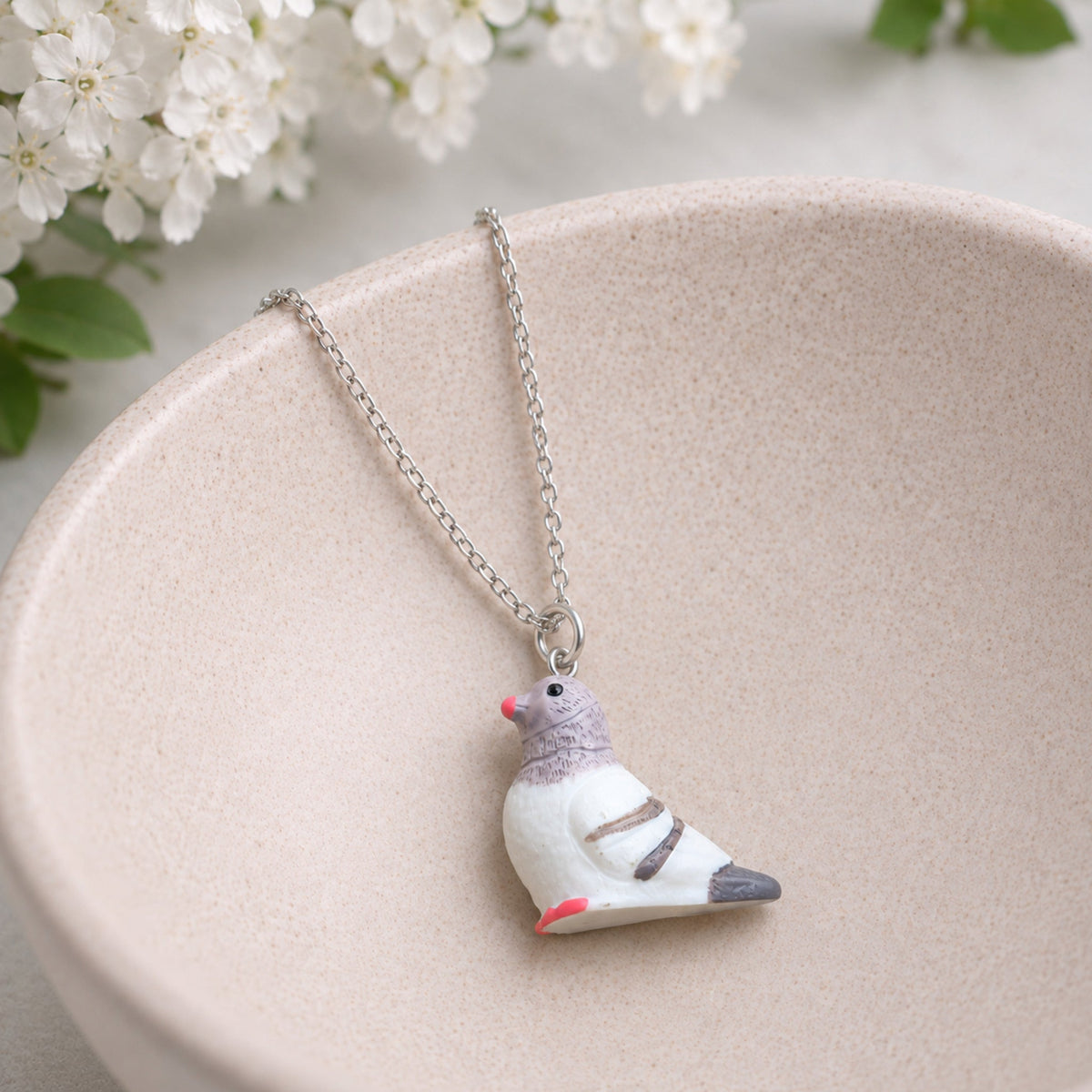 Pigeon Necklace displayed in a jewellery bowl lifestyle photo