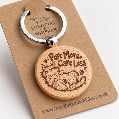 Close-up of Purr More Care Less lounging cat engraving and rounded wooden keyring edge