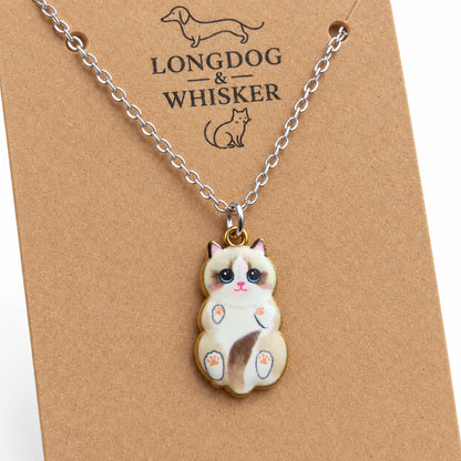 Close-up of the Ragdoll cat pendant with blue eyes, pink paw pads and mixed-tone fittings