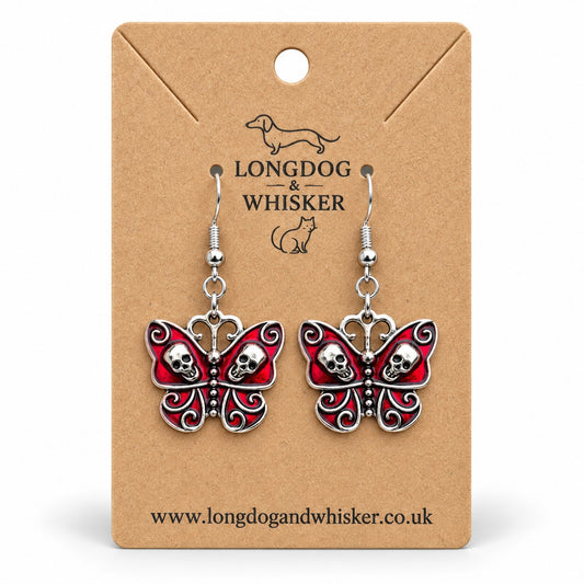 Red skull butterfly earrings with silver-tone skulls and scrollwork on a Longdog & Whisker kraft card