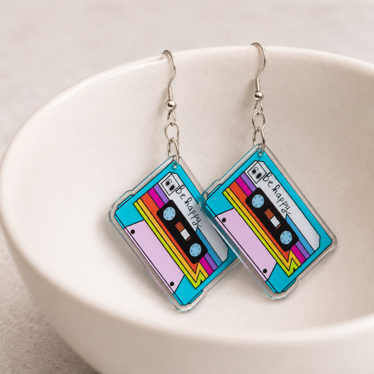 Retro Cassette Tape Earrings hanging from a ceramic bowl