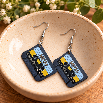 Retro cassette tape earrings displayed in a speckled ceramic bowl