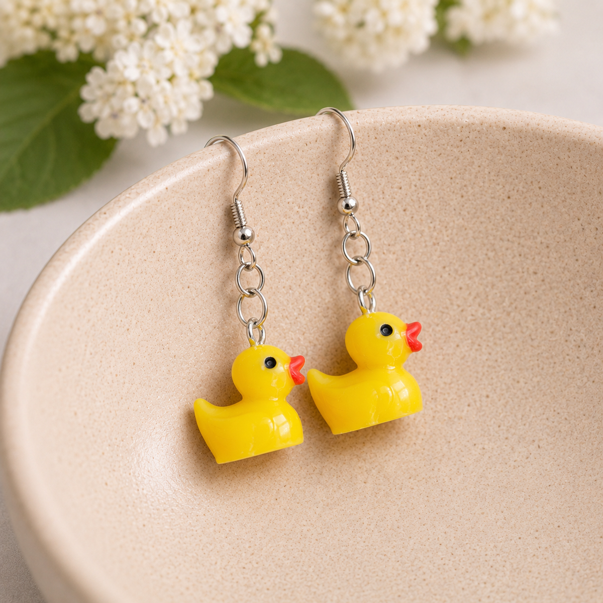 Rubber Duck Earrings hanging inside a ceramic bowl