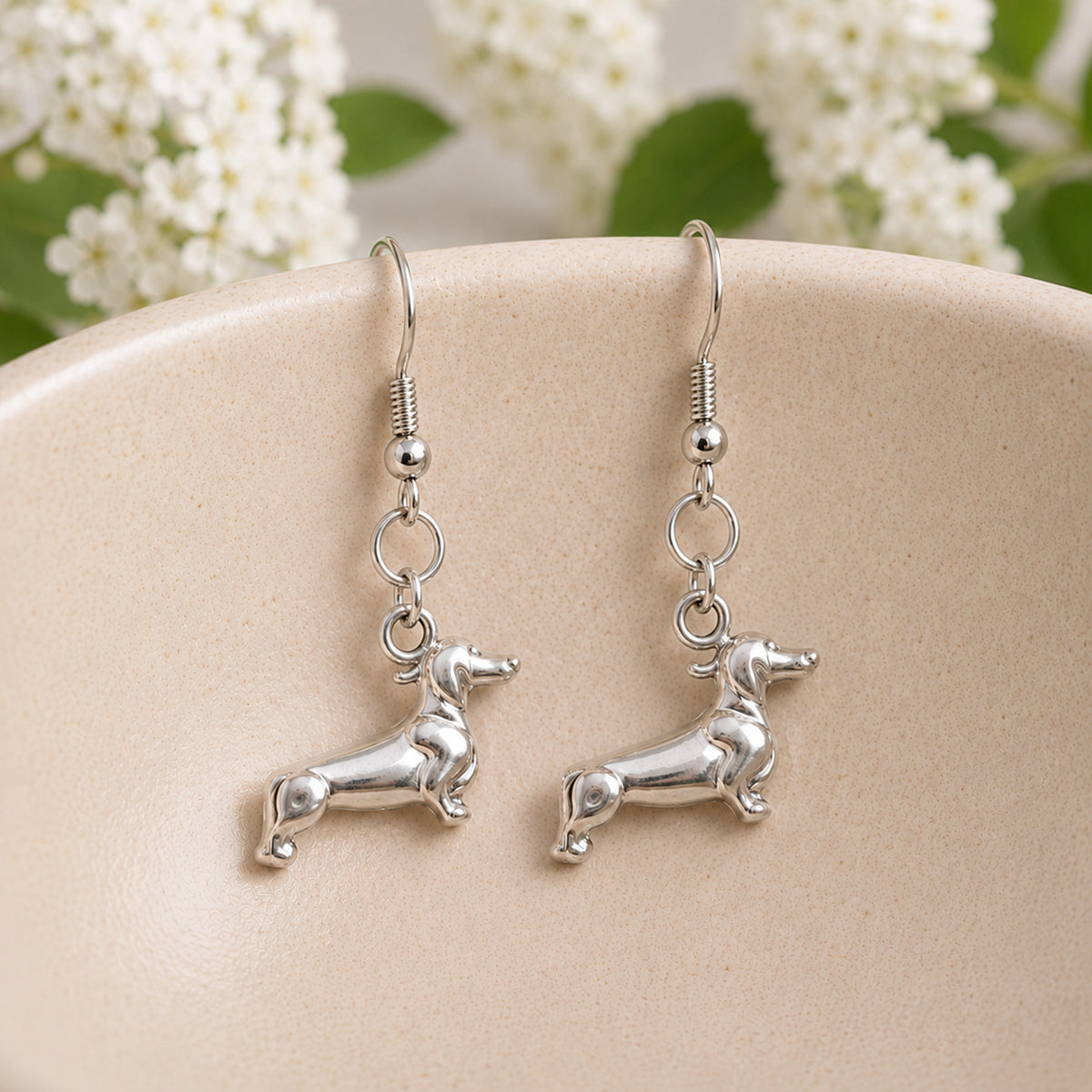 Sausage Dog Earrings - Silver displayed in a lifestyle product photo
