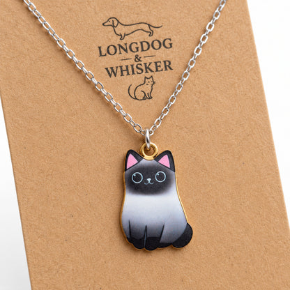 Close-up of the Siamese cat pendant with shaded grey body, dark face and mixed-tone fittings