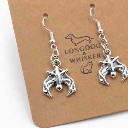 Close-up detail of silver bat earrings on Longdog & Whisker card