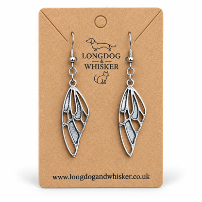 Silver-tone butterfly wing drop earrings on a Longdog & Whisker kraft card