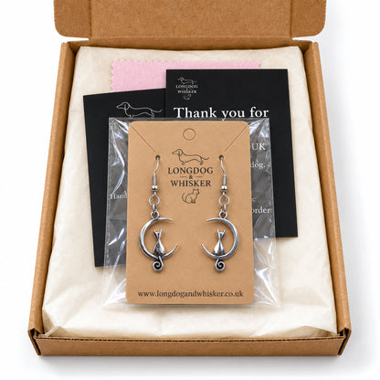 Silver cat and moon earrings in Longdog & Whisker postal packaging.