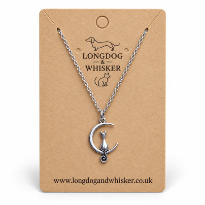 Silver cat and crescent moon necklace on a Longdog & Whisker kraft card.
